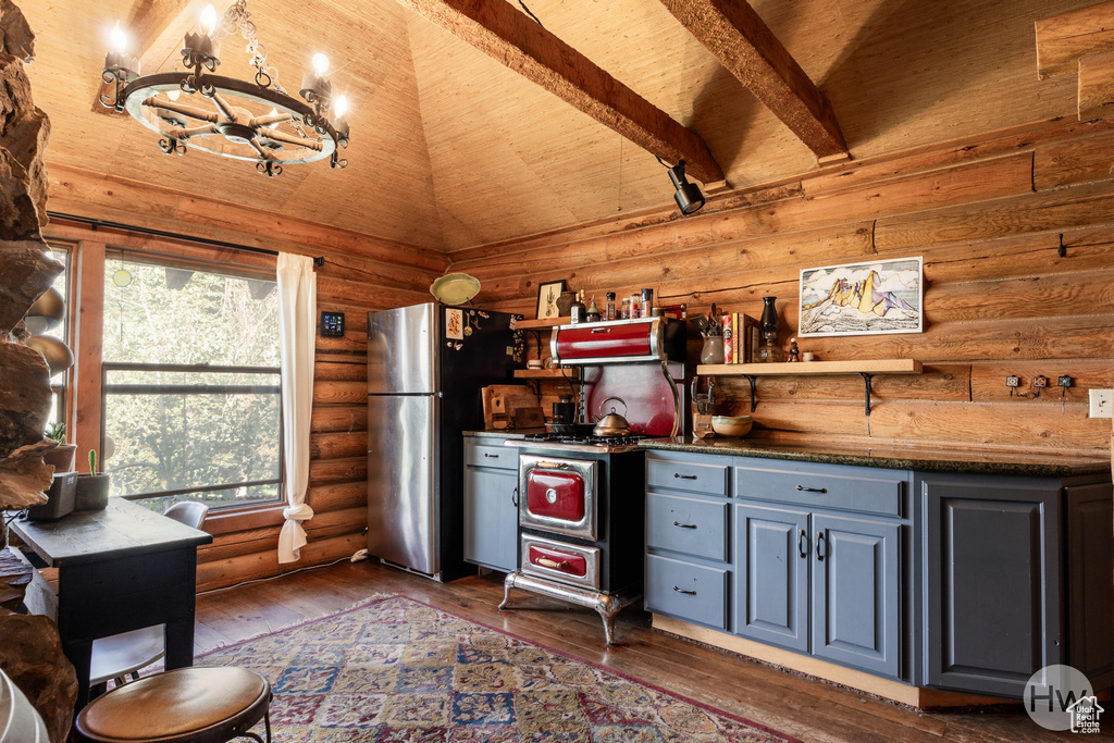 Kitchen with a notable chandelier, freestanding refrigerator, wooden ceiling, lofted ceiling, and rustic walls