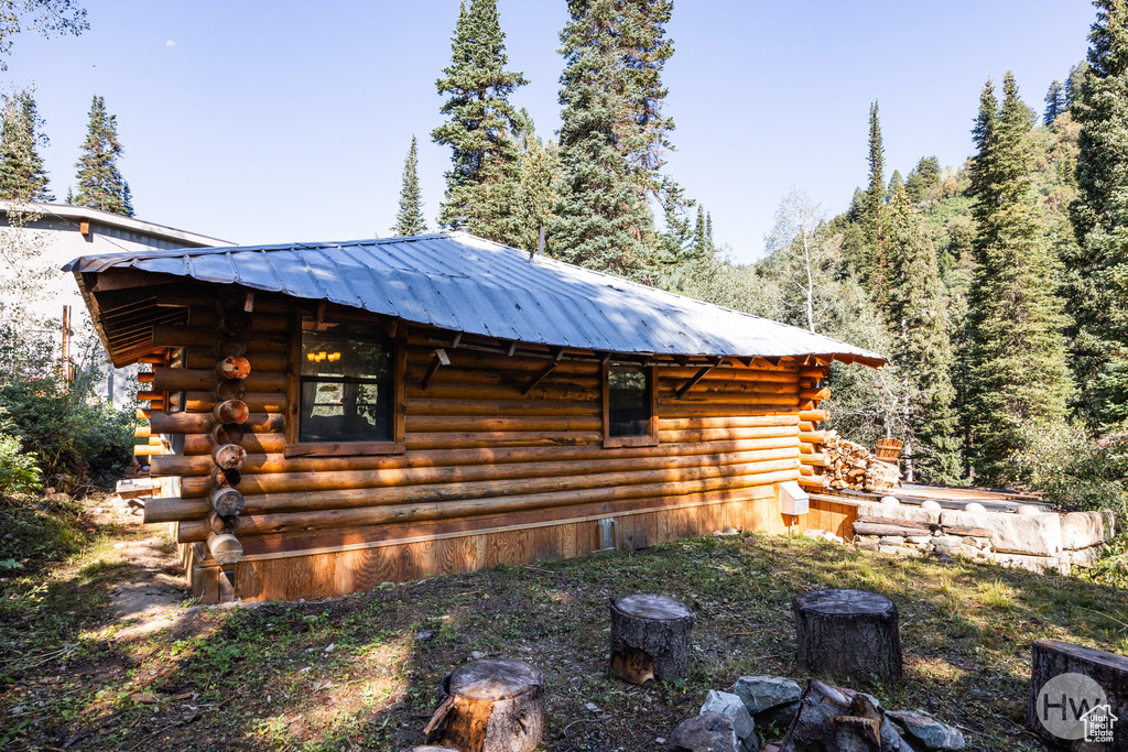 View of property exterior featuring log exterior and metal roof