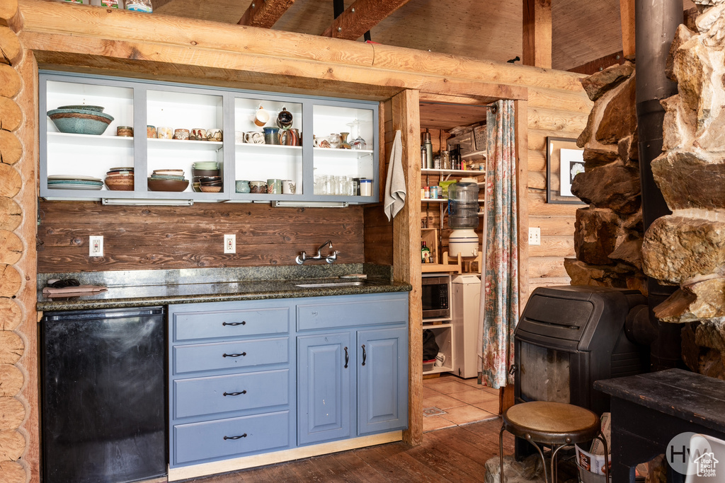 Bar with fridge, a sink, indoor wet bar, dark wood-style floors, and log walls