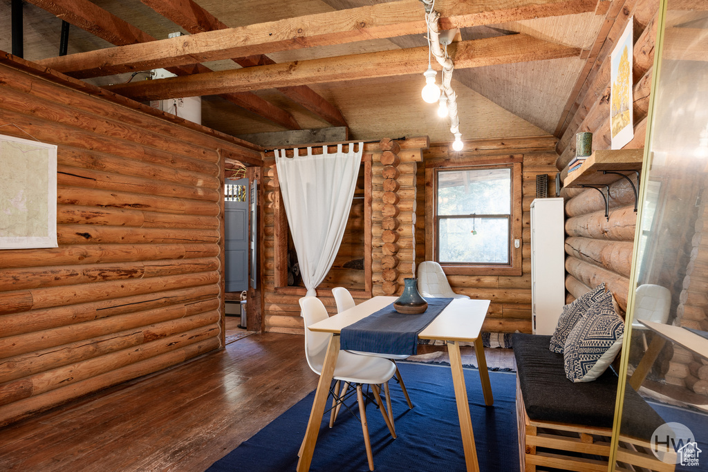 Dining space featuring vaulted ceiling with beams, log walls, wood ceiling, and hardwood / wood-style floors