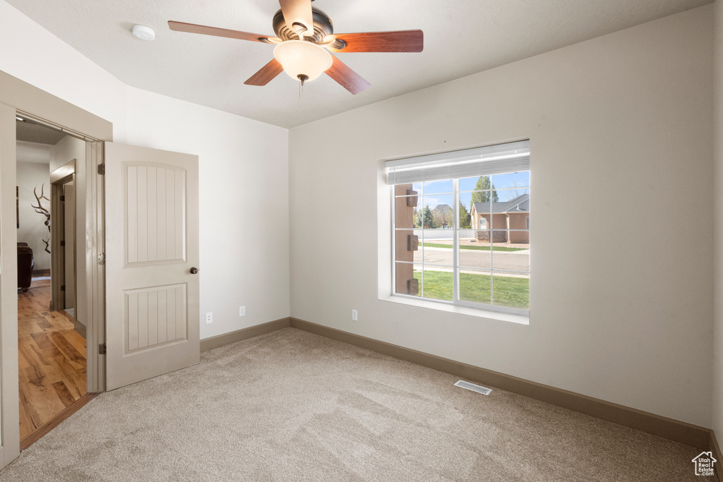 Unfurnished room featuring ceiling fan, visible vents, baseboards, and carpet