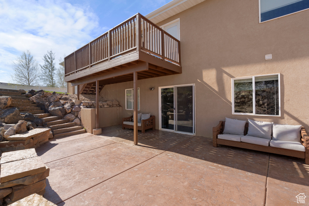 Exterior space with stairs, a wooden deck, and an outdoor hangout area