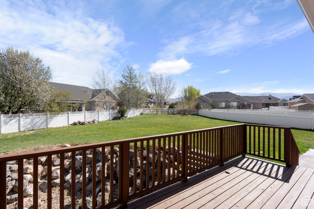 Wooden deck with a residential view, a yard, and a fenced backyard