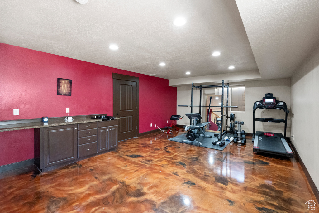 Exercise area featuring baseboards, recessed lighting, and a textured ceiling