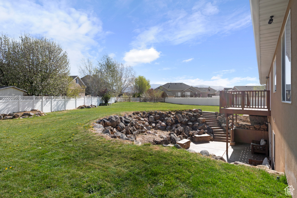 View of yard with a fenced backyard, a patio, a deck, and stairway