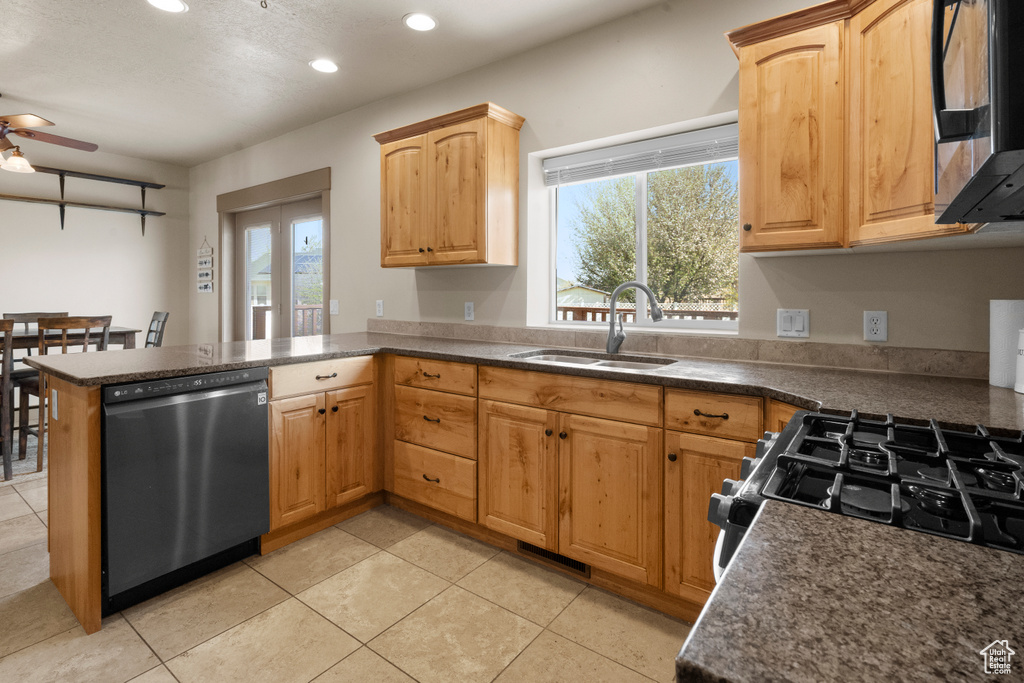 Kitchen featuring a peninsula, dishwashing machine, ceiling fan, recessed lighting, and a sink