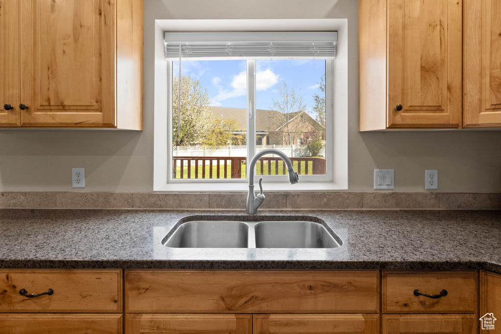 Kitchen with a sink and dark stone counters