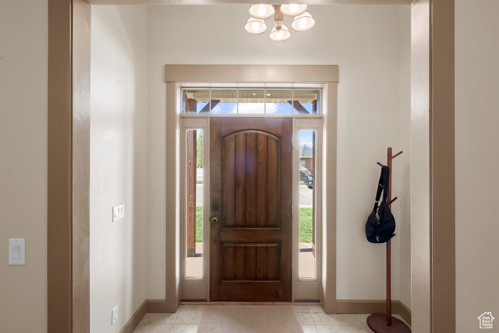 Foyer with baseboards and an inviting chandelier