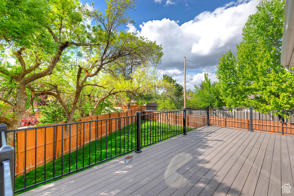 Wooden terrace with a lawn and a fenced backyard