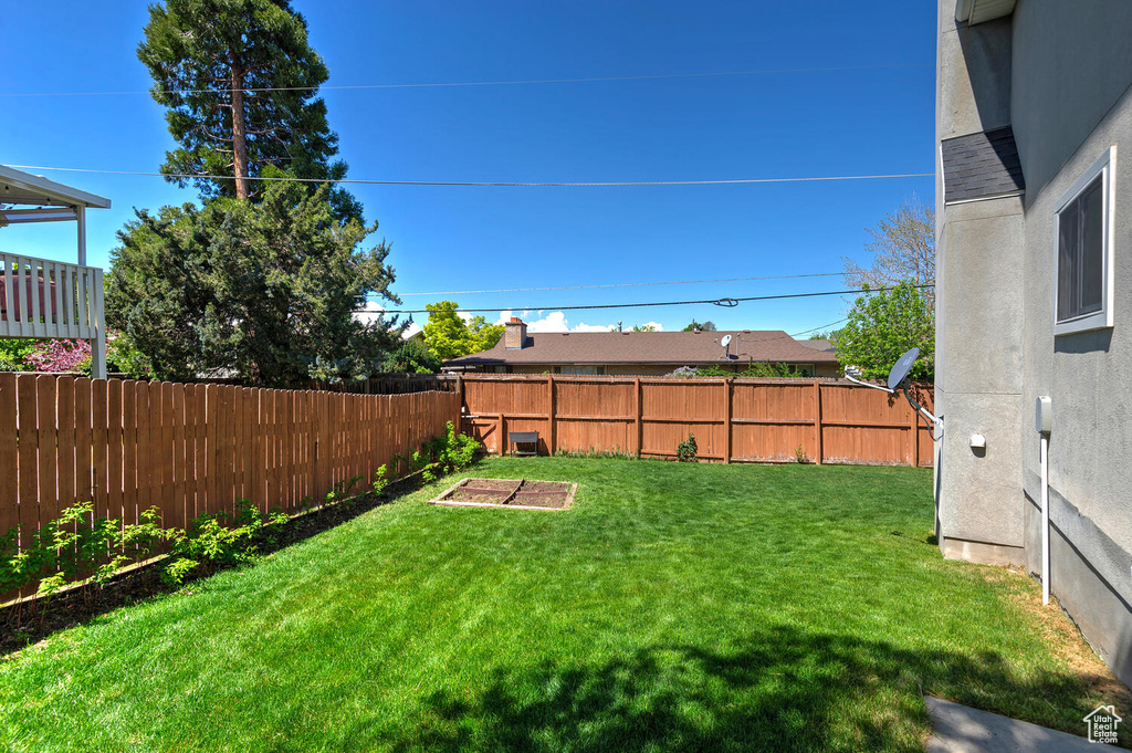 View of yard with a garden and a fenced backyard