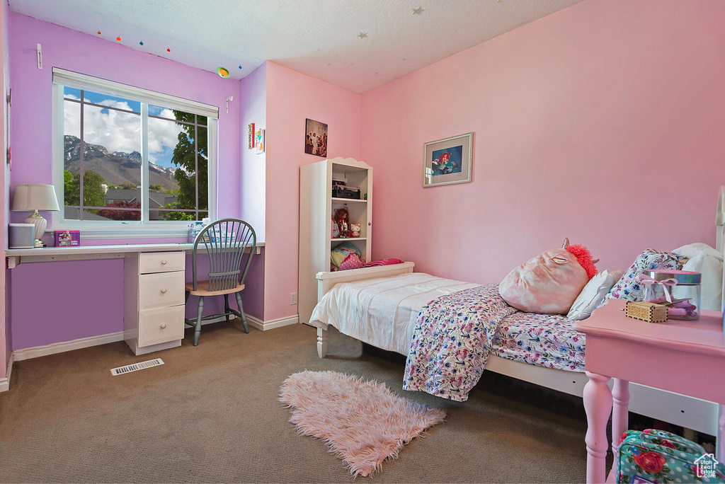 Carpeted bedroom featuring baseboards and visible vents
