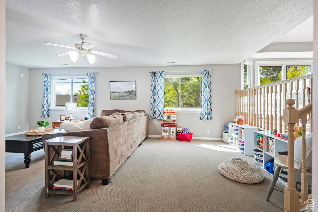 Living room featuring a healthy amount of sunlight, carpet floors, and a ceiling fan