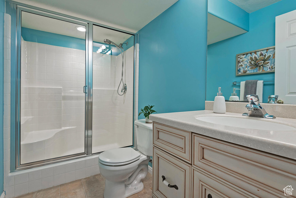 Bathroom featuring vanity, a stall shower, and toilet