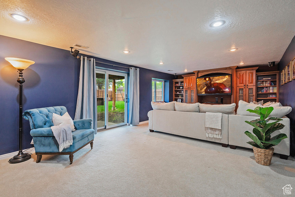 Carpeted living room with recessed lighting, a textured ceiling, visible vents, and baseboards