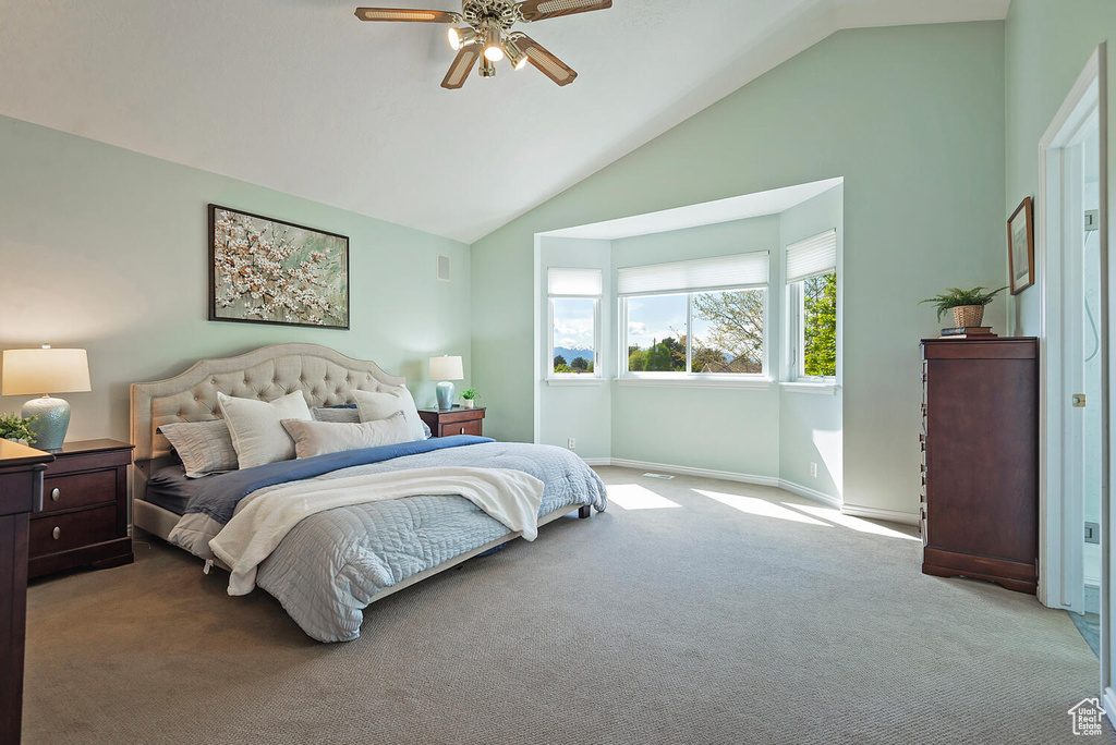 Carpeted bedroom featuring baseboards, a ceiling fan, and high vaulted ceiling
