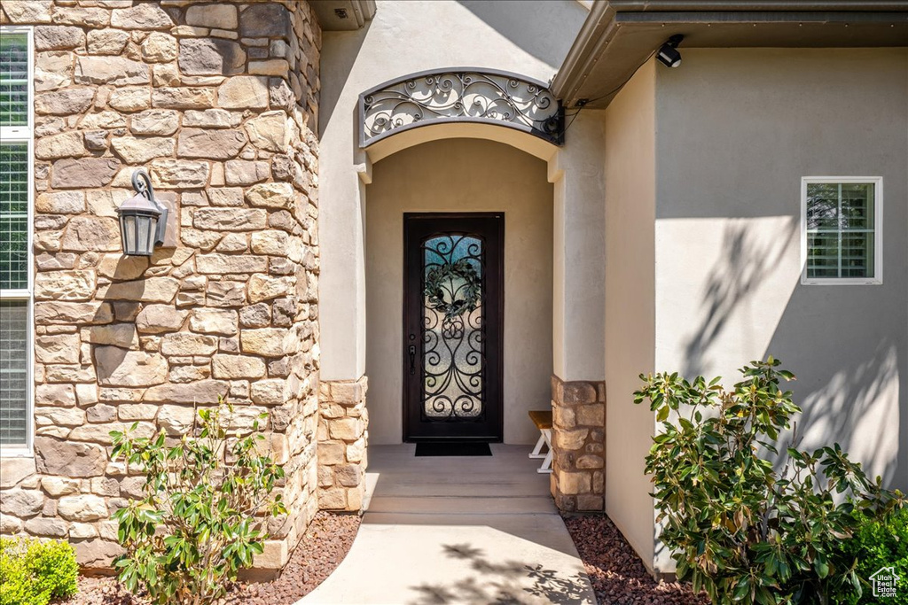 View of exterior entry featuring stucco siding and stone siding