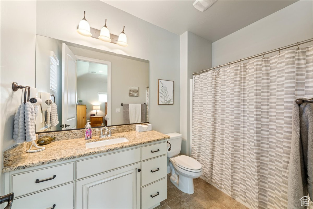 Full bath with toilet, tile patterned floors, ensuite bathroom, and vanity