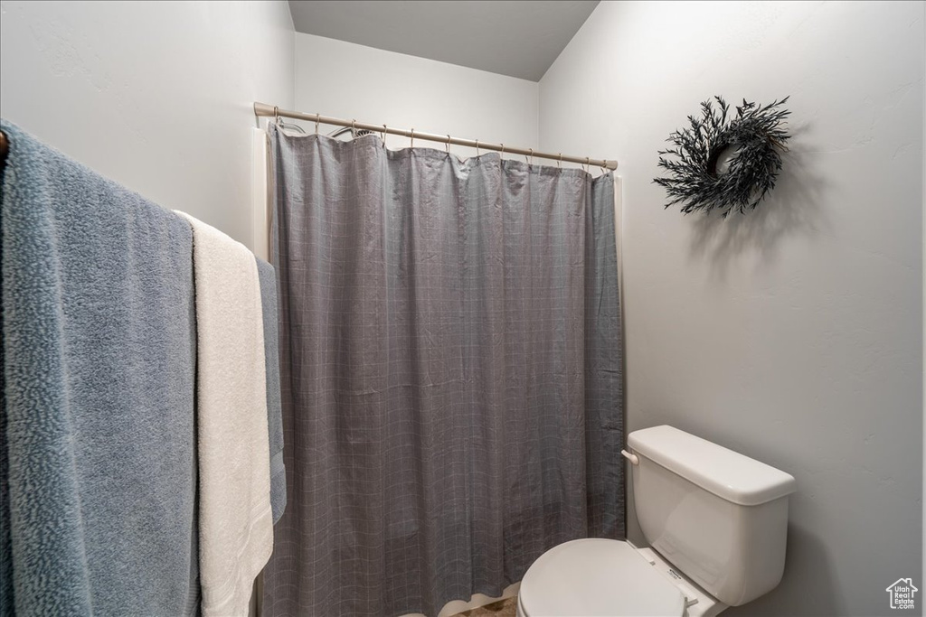 Full bath featuring toilet and curtained shower
