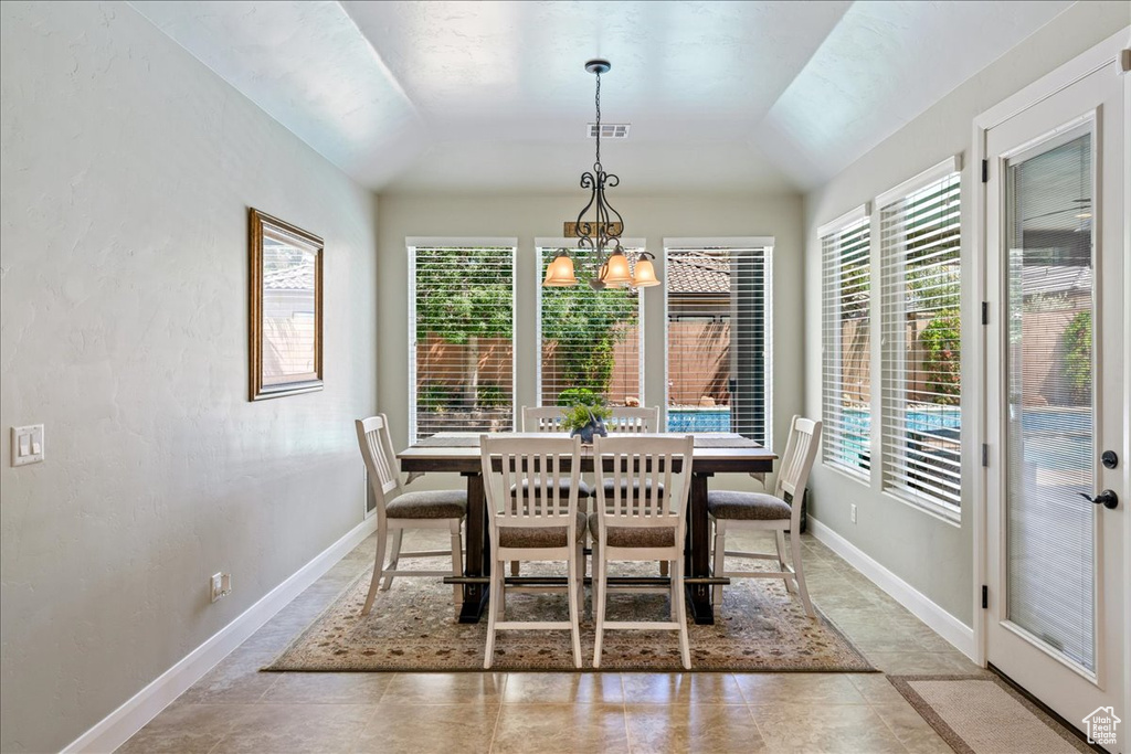Dining room with visible vents, baseboards, a notable chandelier, and vaulted ceiling