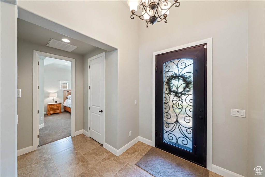 Entryway with baseboards, visible vents, a wealth of natural light, and an inviting chandelier
