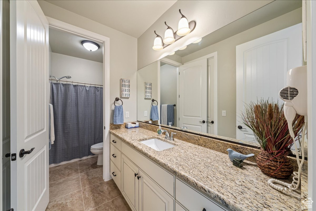 Bathroom featuring toilet, tile patterned floors, and vanity