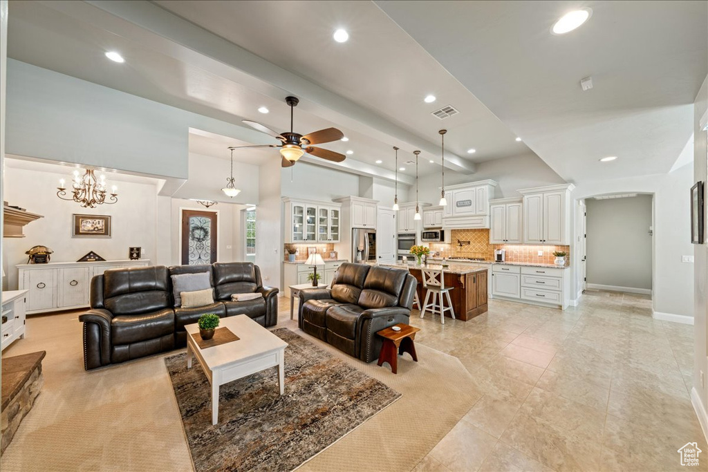 Living area with recessed lighting, baseboards, visible vents, and ceiling fan with notable chandelier