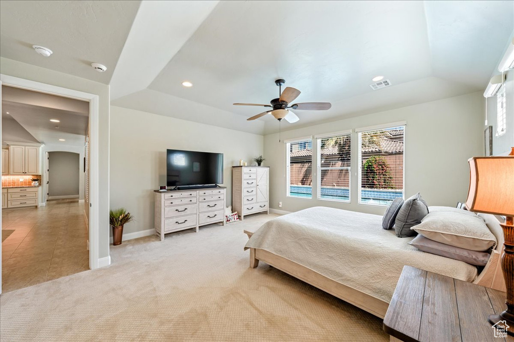 Bedroom with visible vents, baseboards, a tray ceiling, and light colored carpet