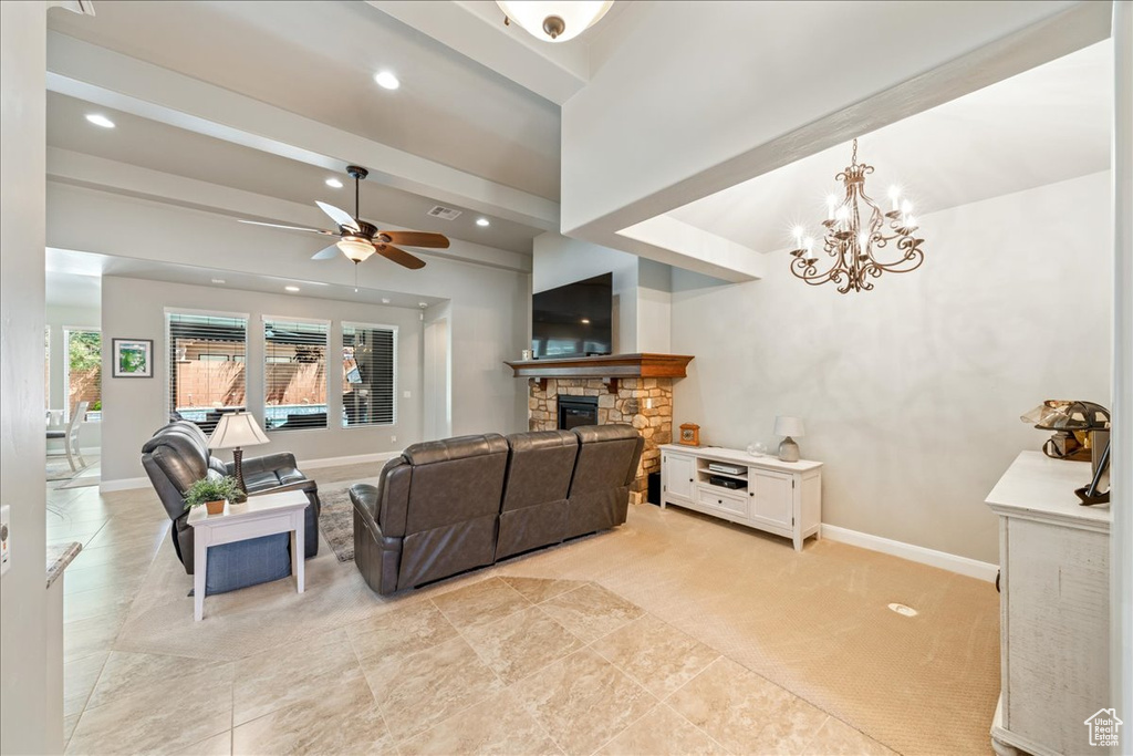 Living area featuring baseboards, a fireplace, ceiling fan with notable chandelier, and recessed lighting