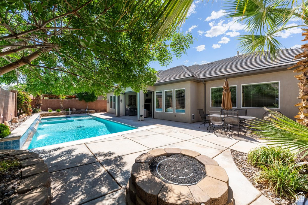 View of swimming pool featuring a fenced in pool, a fenced backyard, a patio area, and a fire pit