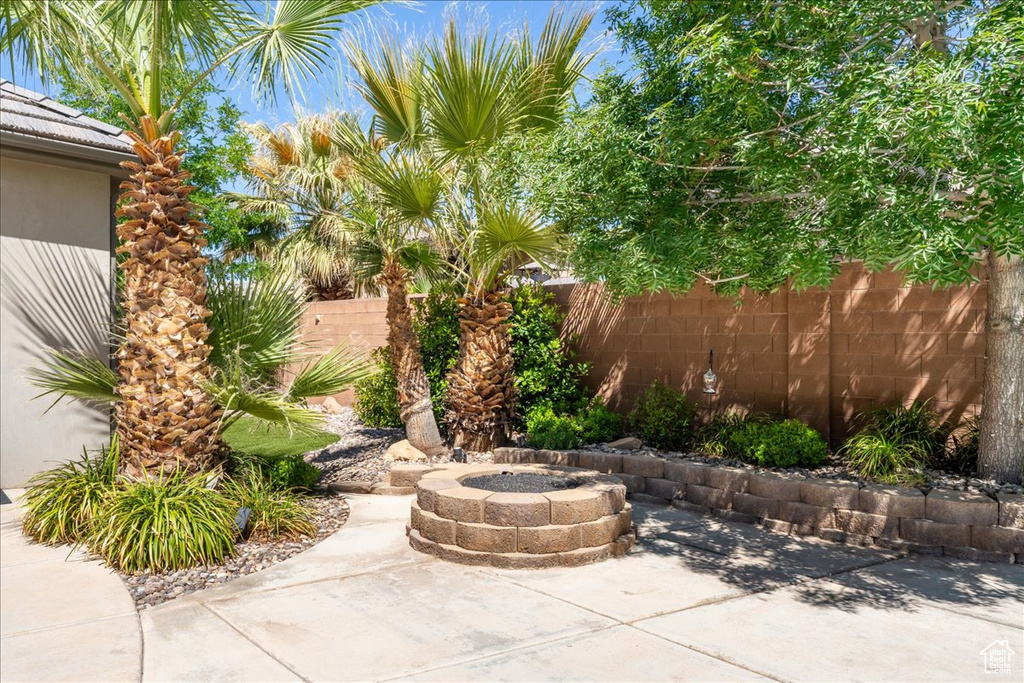 View of patio featuring an outdoor fire pit and fence