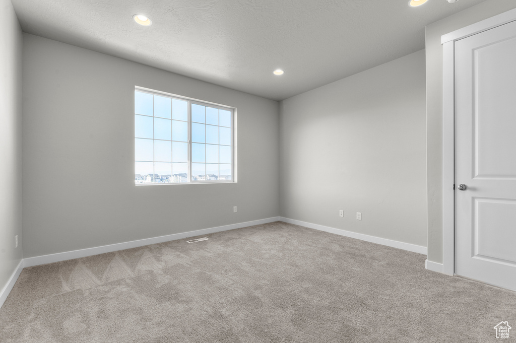 Empty room with carpet floors, recessed lighting, and baseboards