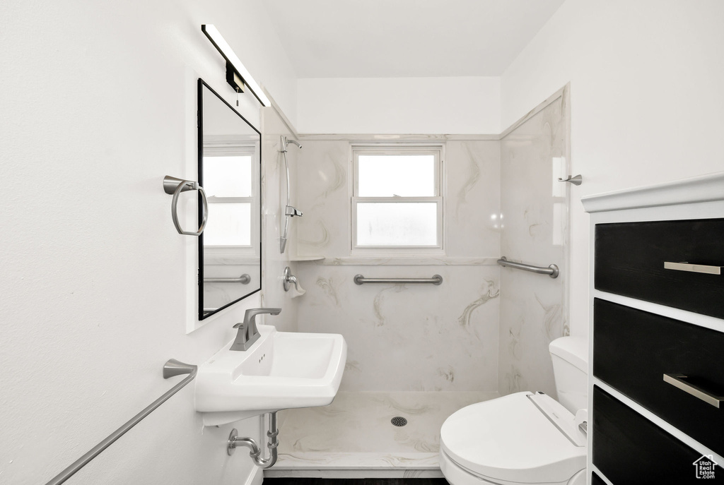 Bathroom with a sink, a shower, and toilet
