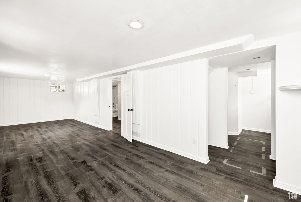 Below grade area featuring baseboards and dark wood-style flooring