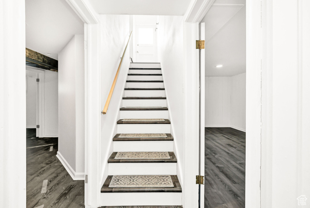 Staircase with baseboards and wood finished floors