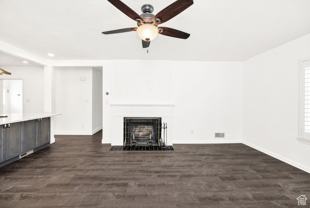 Unfurnished living room with a ceiling fan, a fireplace, baseboards, dark wood-style floors, and recessed lighting