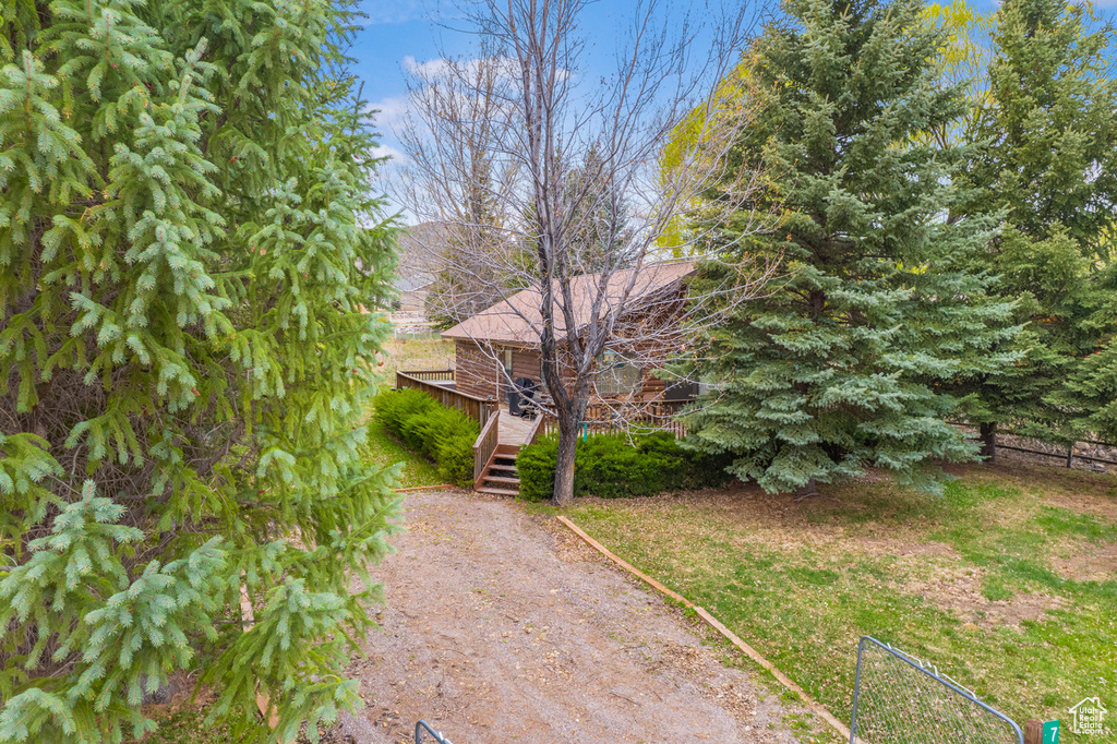 View of property exterior with a wooden deck and driveway
