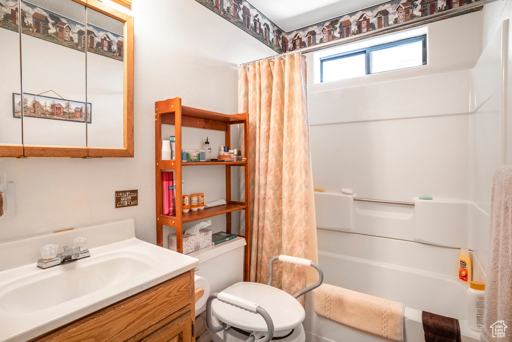 Full bath with vanity, shower / bath combo, and toilet
