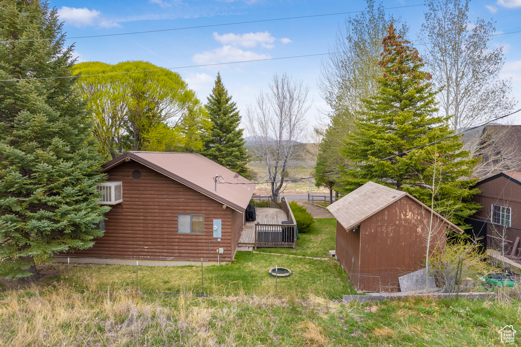 View of side of home featuring a storage shed, an outbuilding, and a mountain view