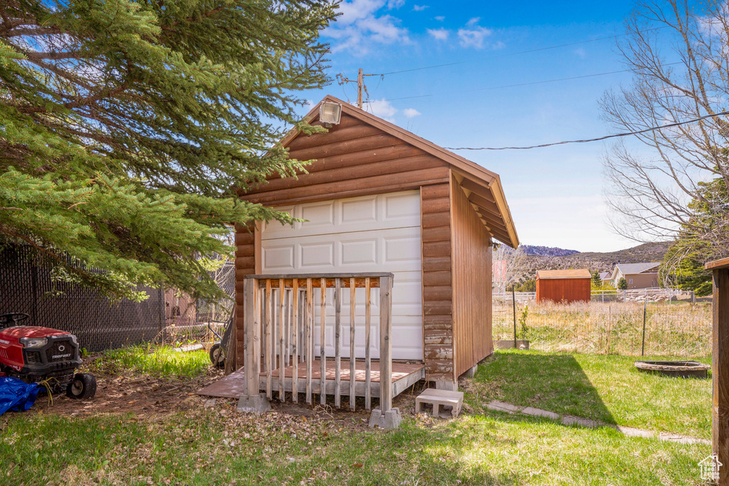View of shed with a mountain view and fence