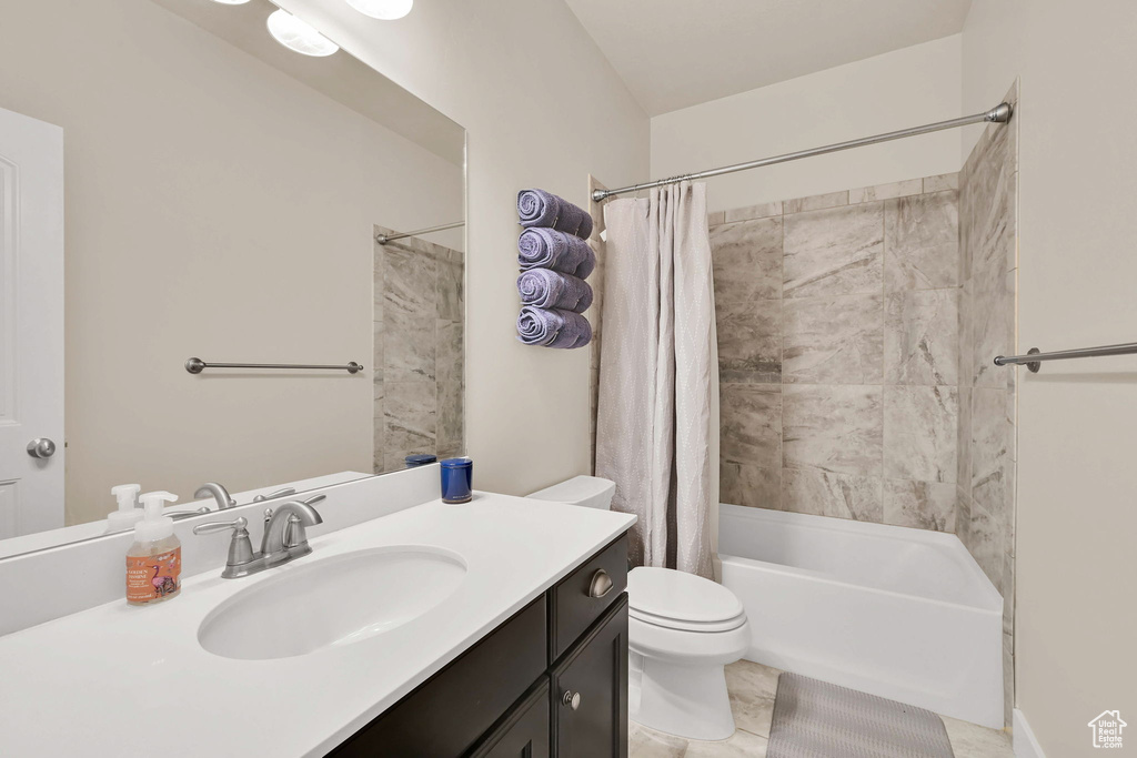 Bathroom with vanity, tile patterned flooring, shower / bath combo, and toilet