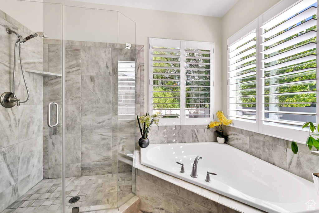 Full bath with a garden tub, a stall shower, and a healthy amount of sunlight