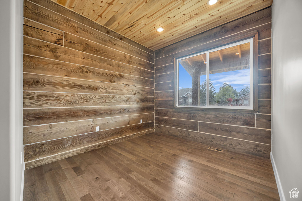 Unfurnished room with recessed lighting, wood ceiling, wooden walls, and dark wood-style floors