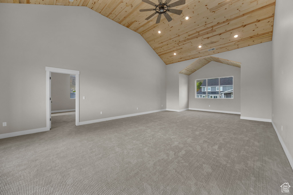 Carpeted empty room featuring high vaulted ceiling, a ceiling fan, recessed lighting, baseboards, and wooden ceiling
