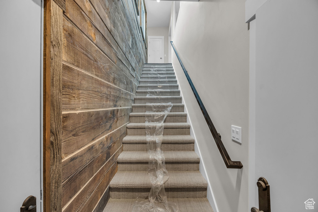 Stairway featuring wooden walls
