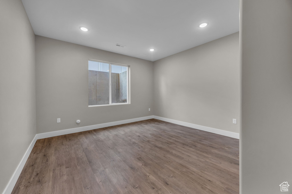 Spare room featuring baseboards, recessed lighting, wood finished floors, and visible vents