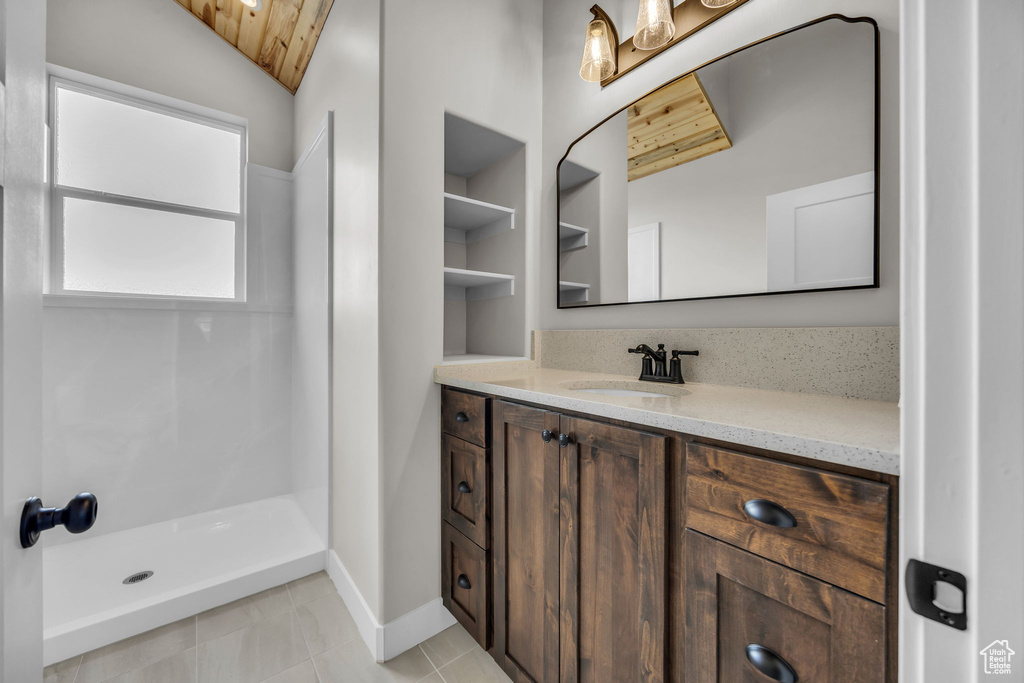 Full bath with wood ceiling, vaulted ceiling, walk in shower, vanity, and baseboards