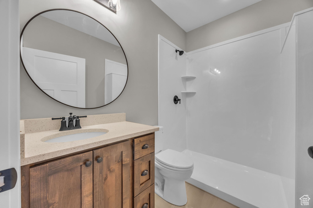 Bathroom featuring vanity, a shower, and toilet