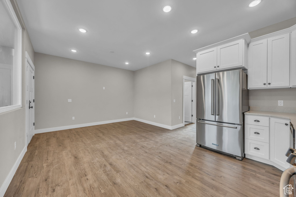 Kitchen featuring freestanding refrigerator, white cabinetry, and recessed lighting