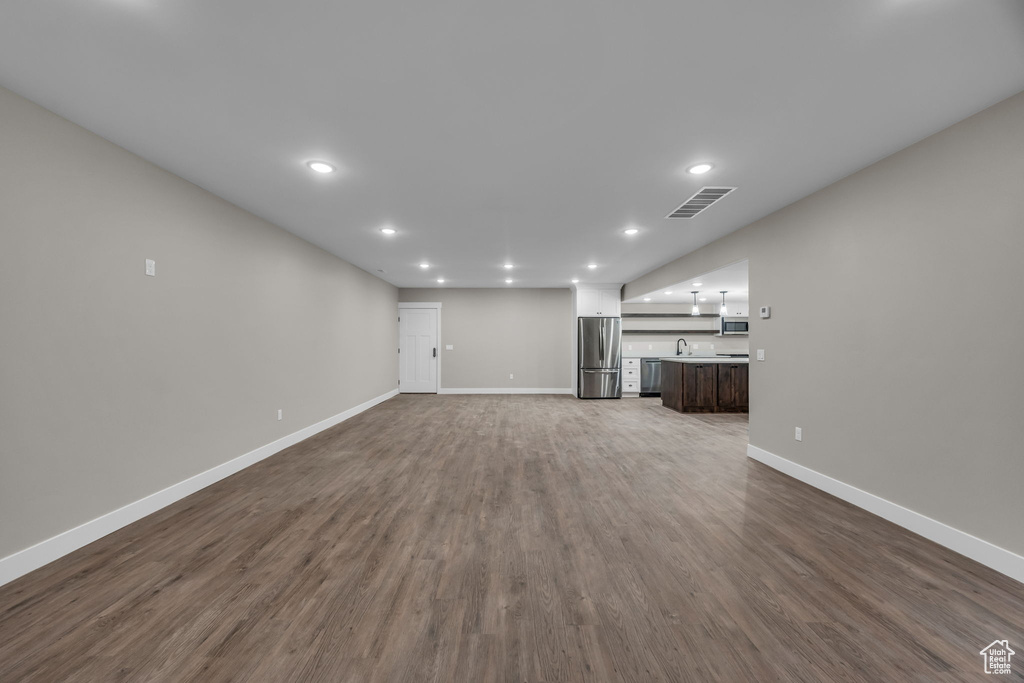 Unfurnished living room with baseboards, recessed lighting, and visible vents