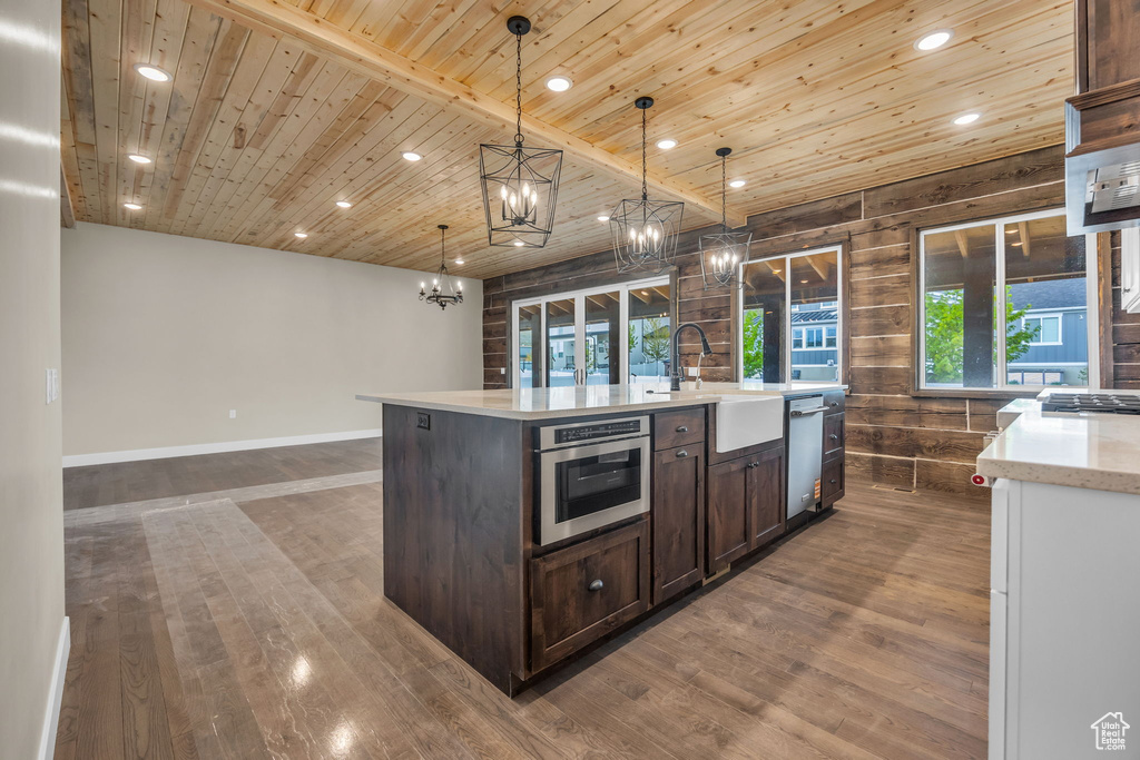 Kitchen with dark brown cabinets, a sink, wooden ceiling, an inviting chandelier, and dark wood-type flooring